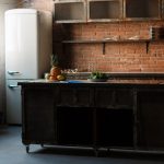 dark-loft-kitchen-with-red-brick-wall-kitchen-table-cutlery-spoons-forks-breakfast-fruit-4745914